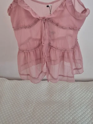 Rosa topp med volanger - Så fint rosa linne med volanger, liknar populära toppen från Zara💘 Storlek XS, stor i storleken. Passar M. Perfekt under sommaren! Helt ny med prislapp. 