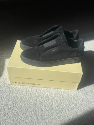  Axel Arigato svarta-laceless - Säljer nu mina helsvarta Axel Arigato laceless skor. Skorna har inte använts så väldigt mycket men har tyvär någon fläck på båda skorna (se bild 3), annars är de i väldigt bra skick. Skobox och dustbag ingår. Vid frågor hör av dig!