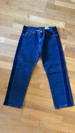 Blå jeans från MAX&Co. - Säljer ett par snygga blå jeans från MAX&Co. i rak modell. Jeansen har en cool tvåtonseffekt med mörkare blå sidor och klassisk femficksdesign. Tillverkade i slitstark denim med knapp- och dragkedjegylf. Perfekta för en trendig och avslappnad look.