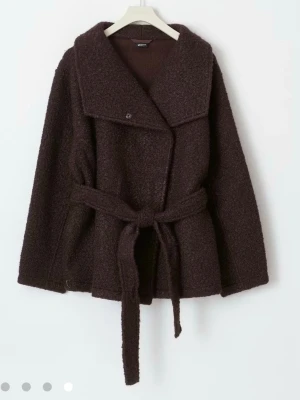 Gina Tricot Soft Belted Jacket - Brun - Supermysig och fin kappa i bouclé och knyts med ett band vid midjan. Kappan är oversized i storlek och täcker precis rumpan på mig som är 168 cm lång. Kommer dock inte till användning då jag inte passar så bra i den :( Slutsåld i butik & på hemsidan så passa på!! 🩷🩷