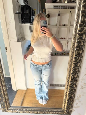 Vit stickad tröja med puffärm - Säljer en vit stickad tröja med korta puffärmar och bred ribbad kant nedtill. Tröjan har en rund halsringning och är gjord i ett mjukt material som passar perfekt till både jeans och kjol. Enkel och stilren design som funkar året runt.