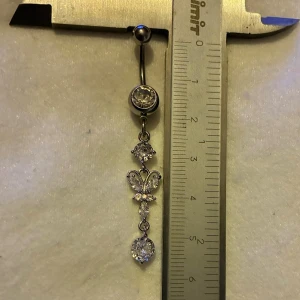 ✨ NY oanvänd navelpiercing med hänge - Kirurgiskt stål 316L  - ✨ NYTT oanvänt smycke i kirurgiskt stål! 🌸 Hållbart & Rostfritt: Slitstarkt 316L-stål som inte oxiderar eller rostar av fukt. 🌸 Säkert: Industristandard, skonsamt för läkta piercingar.  🛍️ 30 % BUNDLE-RABATT! Köp fler artiklar från min shop och få 30 % på allt! ✨ 📦 Frakt: Endast spårbart via Plick SafePay för vår trygghet.