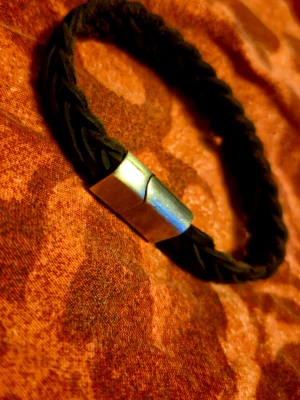 Svart flätat armband med magnetlås - Stilrent svart armband med flätad design och ett coolt magnetlås i silverfärgad metall. Perfekt accessoar för att lyfta din outfit med en enkel men snygg detalj. Nypris 700 aldrig använd