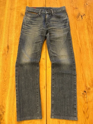 Edwin Blue Trip Jeans (W28) 🇯🇵 - Edwin Blue Trip Jeans (W28) 🇯🇵 Dark indigo fade shifting into blue-grey tones with rich vertical slub texture • Signature leather-trim back pockets & red arcuate stitching • Blue Trip rivets & bold leather patch • Straight leg, relaxed drop • Red pocket lining & gold zip • Natural wear to leather adds character Rare sub-line with strong Y2K Japanese denim energy  Feel free to ask for more details! (10)