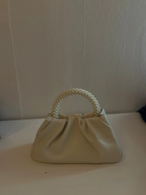 Vit handväska med pärlhandtag - Superfin vit handväska i mjukt konstläder med ett handtag täckt av pärlor. Från Even&odd aldrig använd och nypris 229 kr🫶🏻