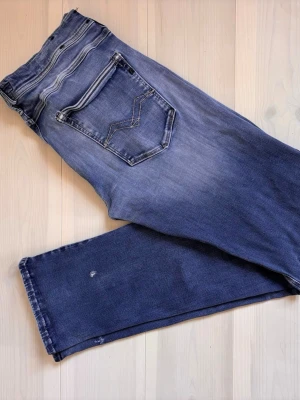 Replay Jeans - Snygga blå jeans från Replay. Jeansen har en något tvättad finish och raka ben. Perfekta till vardags för en avslappnad stil. Storlek W32
