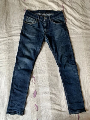 Mörkblå jeans från tiger of sweden - Snygga mörkblå jeans från tiger of sweden med klassisk femficksdesign och diskreta slitningar. Jeansen har dragkedjegylf och är tillverkade i stretchigt denim för en bekväm passform. Perfekta för en avslappnad och trendig look. Skriv om du har några funderingar!😁