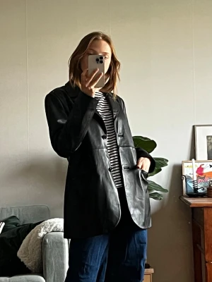 Svart oversized skinnjacka/kavaj/blazer - Svart oversized skinnjacka från STOCKH LM. Jackan har rak passform och två fickor framtill. Stilren och klassisk! Köpt för 1200kr
