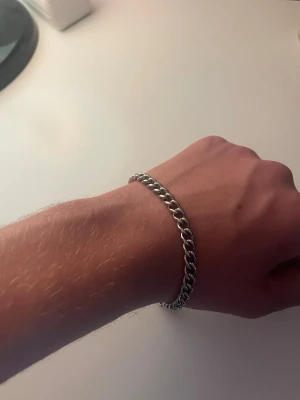 Silverfärgat kedjearmband från BoA - Snyggt armband i silverfärgad metall med klassisk kedjelänk och karbinlås. Armbandet har en liten rektangulär bricka med BoA-loggan. Perfekt accessoar för en stilren look.