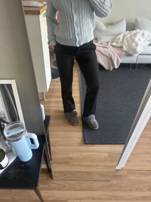 Svarta raka kostymbyxor - Snygga svarta kostymbyxor med rak passform och klassiska fickor. Byxorna har hällor för skärp och är perfekta för en stilren look. Materialet ser ut att vara en mjuk och följsam textil som ger en dressad känsla.