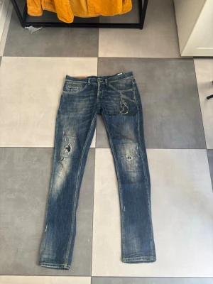 Dondup George Jeans Med Slitningar - Säljer nu mina schyssta DonDup George i storlek 30/32!🔥 Riktigt snygga, slitningar från fabrik (sällsynt) 👌 | Jeansen har ett lagat hål som släppt lite, men kan också bara vara designen(är osäker)!✅ | Gott skick, snygga slitningar | Snabb affär = priset sänks! 🚚Alltid frakt inom 24h🚚