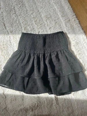 Svart volangkjol från Gina Tricot - Supersöt svart kortkjol från Gina Tricot med coola paljettdetaljer runt hela kjolen!! 