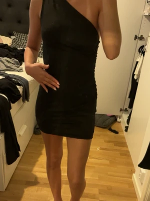 Svart one shoulder kort klänning - Säljer en kort svart one shoulder klänning i stolek xs 
