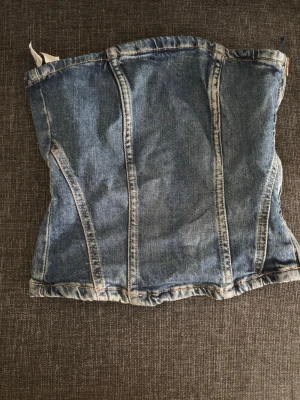 Denim korsett med dragkedja - Snygg denimkorsett i klassisk blå jeansfärg med markerade sömmar och dragkedja i sidan använd en gång