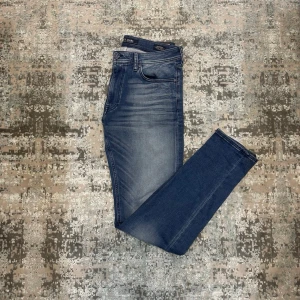 Mörkblå jeans från Loft - Snygga mörkblå jeans från Loft med klassisk femficksdesign och diskret slitning framtill. Jeansen har en slim passform och normal midja, perfekta till en avslappnad stil. Materialet är mjukt denim med stretch för extra komfort.
