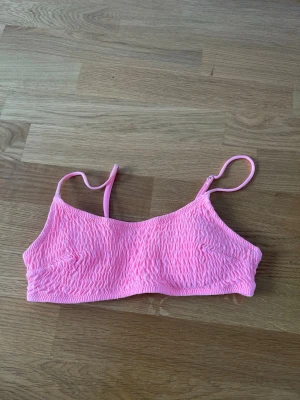 Rosa bikini med smock och tunna band - Söt rosa bralette med smockad struktur och tunna justerbara axelband. Mjuk och stretchig modell utan bygel, perfekt för en avslappnad och bekväm stil. Passar dig som gillar en enkel och trendig look.