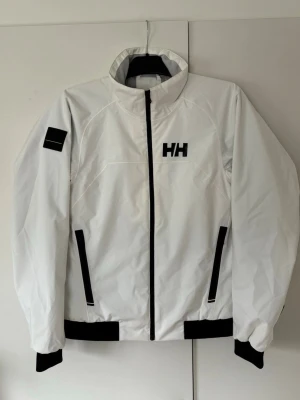 Vit jättefin Helly Hansen regnjacka M - Sjukt snygg högkvalitativ vit Helly Hansen regnjacka i storlek M säljes. Superfint utmärkt skick knappt använd någonting så riktigt kap!Grym passform perfekt nu till sommaren och tveka inte vid minsta fråga eller fundering.