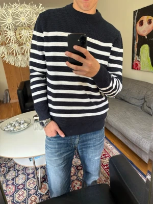 Marinblå och vit randig stickad tröja - Säljer en snygg stickad tröja med marinblå och vita horisontella ränder. 