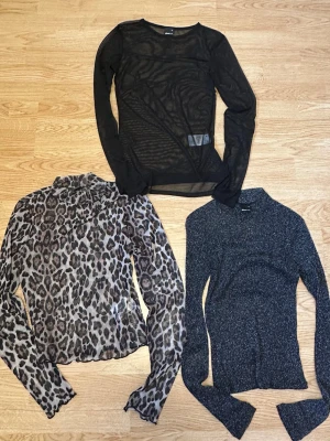 Tre mesh toppar svart glitter brun leo - Tre långärmade mesh-toppar: en svart, en svart-glittrig, en leopardmönstrad. Gina Tricot. Strl XS