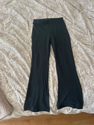 Svarta utsvängda leggings - Svarta leggings med utsvängda ben och hög midja. Mjukt och stretchigt material som sitter skönt på kroppen. 