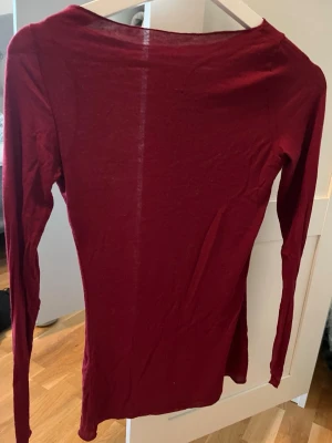 Vinröd Intimissmi topp  - En enkel och stilren vinröd långärmad topp med rund halsringning. Tunt och mjukt material som sitter tight mot kroppen. 