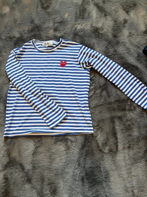 Comme des garcons randig longsleeve  - Säljer en blå/vit randig comme des garcons långärmad tröja. Köpte tröjan begagnad till mig men den var för liten. Men han jag köpte av hade aldrig använt den och jag har ju inte heller använt så helt ny alltså. Perfekt inför sommaren till linnebyxor eller till ett par jeans på våren. Storlek S