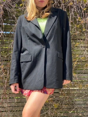 Svart oversized kavaj - Stilren svart kavaj med klassisk krage och en knapp framtill. Modellen är oversized med raka axlar och två fickor med lock rocka denneeee ❤️‍🔥❤️‍🔥❤️‍🔥