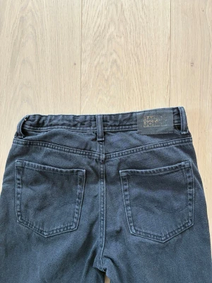 Jack & Jones Jeans svarta 158 - Snygga svarta jeans från Lindex med rak passform och klassiska fem fickor. Jeansen har bälteshällor och stängs med knapp och dragkedja. Perfekta för en avslappnad och stilren look.