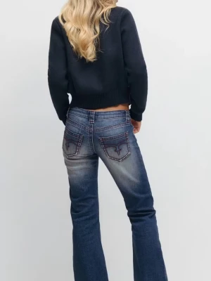 Blå bootcut jeans med broderade fickor - Snygga blå bootcut jeans med broderade detaljer på bakfickorna. Jeansen har en klassisk femficksmodell och är tillverkade i ett slitstarkt denimtyg. Passformen är normal och benen har en lätt utsvängd siluett. Perfekta för dig som gillar en retroinspirerad look. 