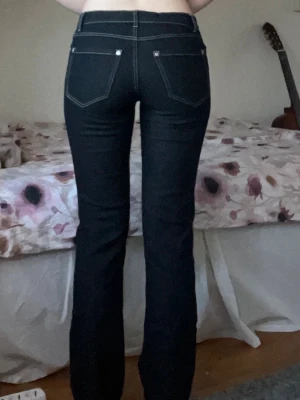 Svarta raka jeans med kontrastsömmar - Snygga svarta jeans i en ”momjeans” modell med medelmidja, raka ben och vita kontrastsömmar. Materialet känns som jeans men är lite stretchigare. Står storlek 36 men skulle säga att den är 34/XS.☀️