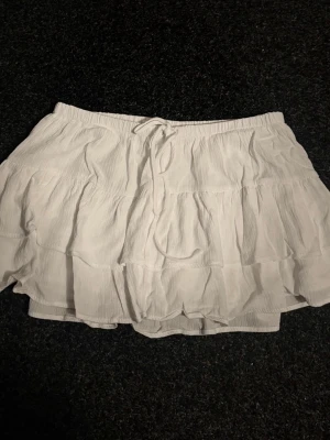Vit volangkjol från Pull&Bear - Använd en gång. Nypris 299 kr. Du betalar frakten. Kjolen har ett par insydda shorts.                                                                 Det är bara att höra av sig om du har funderingar🤗