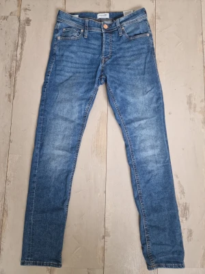 Blå slim jeans från Gina Tricot - Säljer ett par klassiska blå slim fit jeans från Gina Tricot. Jeansen har fem fickor, normal midja och är tillverkade i mjuk bomull med lite stretch. Perfekta till vardags och lätta att matcha med olika stilar.  Storlek 28 33