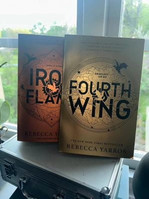 Fourth Wing & Iron Flame av Yarros - Säljer två snygga fantasyböcker: 'Fourth Wing' och 'Iron Flame' av Rebecca Yarros. Båda har mjuka omslag i metalliskt guld och koppar med drakmotiv och tydliga titlar. Perfekta för dig som gillar episka äventyr och magi.