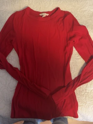 Röd långärmad topp - En enkel och snygg röd långärmad topp med rund halsringning. Modellen passar perfekt till jeans eller kjol. Materialet är bekväm att bära hela dagen.
