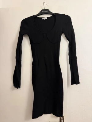 Svart ribbad långärmad klänning - Snygg svart ribbad klänning från KappAhl med lång ärm och markerad byst. Klänningen har en kroppsnära passform och rundad ringning. Perfekt för dig som gillar stilrena och trendiga plagg.
