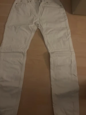 Vita Lee jeans - Säljer ett par vita jeans med rak passform och klassisk femficksdesign. Jeansen har bälteshällor och knappgylf. Perfekta för dig som vill ha en clean och stilren look till vardagsoutfit. Har 3 par alla till salu, paketpris 800 för alla 