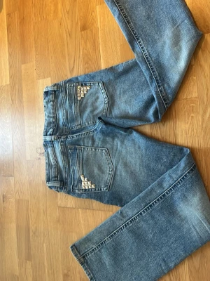 Blå bootcut jeans med nitar - Säljer ett par blå bootcut jeans med snygga silverfärgade nitar på bakfickorna. Jeansen är från Gina tricot och jag har själv dekorerat bakfickorna och man kan lätt ta bort dem.