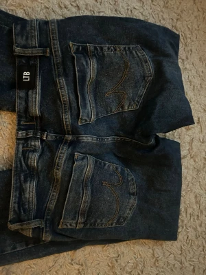 Mörkblå bootcut/raka  jeans från LTB - Snygga mörkblå jeans från LTB med lite utsvängda ben och klassiska bakfickor med dekorativa sömmar. Jeansen har normal midja och är tillverkade i ett slitstarkt denimtyg. Perfekta för en avslappnad och trendig look.
