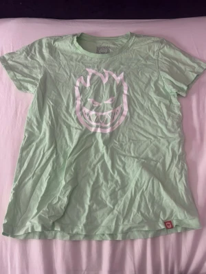 Mintgrön T-shirt  - Snygg mintgrön t-shirt från Spitfire med det klassiska eldsflammeloggan i vitt på bröstet. Säljer den eftersom jag inte använder den längre. Använd fåtal ggr. Storlek XL barnstorlek 