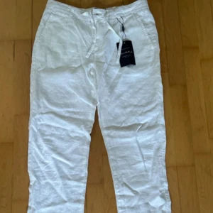 Vita linnebyxor från Bondelid - Säljer ett par fräscha vita linnebyxor från Bondelid. Byxorna har avslappnad passform, dragsko i midjan och är tillverkade i 100% linne för en luftig känsla. Perfekta för nu inför sommaren. Inte använde en ända gång. Hör av dig vid minsta lilla fundering! 