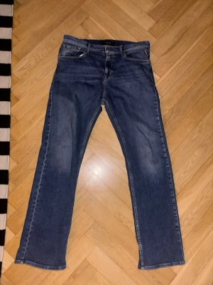 Blå raka jeans från REPLAY - Klassiska blå jeans från Replay med rak passform och fem fickor. Jeansen har en lätt tvättad look och är tillverkade i denim. Perfekta för en avslappnad stil och passar till det mesta. Midja-40cm, L-98 cm. Pris kan diskuteras.