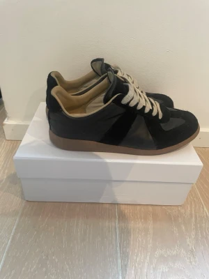 Svarta Maison Margiela sneakers - Säljer dessa feta Maison Margiela skorna som är i färgen svart. Skon är använd men är fortfarande i ett mycket bra sick. Storlek: 42