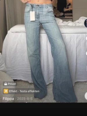 Ljusblå bootcut jeans låg midja - Säljer ett par ljusblå bootcut jeans med låg midja och klassisk femficksdesign. Jeansen har en avslappnad passform över låren och utsvängda ben. Perfekta för en trendig och avslappnad stil.