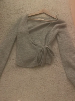 Grå omlott tröja - Säljer denna jätte fina omlott kofta/ tröja från Gina tricot i storlek XS! Jag säljer den för att jag inte använder den❤️ Kostade 400 i nypris. 🪸