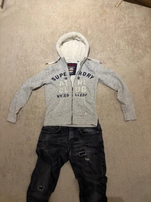 Zip-hoodie från Superdry - Säljer denna extremt stilrena hoodie från superdry. Väldigt mjuk och skönt material i luvan och perfekt att ha nu i kallare tider. Det sår storlek M men den är storlek S skulle jag säga. S/XS