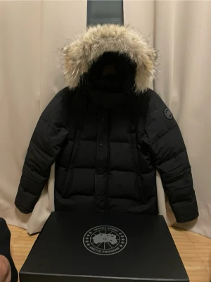 Canada Goose Wyndham Parka Black Label M - Säljer min Canada Goose Wyndham Parka Black Label i svart. Jackan är i väldigt fint skick, sparsamt använd och utan skador. • Storlek: M • Färg: Svart • Modell: Wyndham Parka – Black Label • Äkta päls (avtagbar) • Originalbox + kvitto finns (köpt ny) • Nypris ca 16 700 Supervarm och stilren vinterjacka som funkar perfekt både till vardag och finare tillfällen.  💰 Pris: 4900 kr (kan diskuteras vid snabb affär) 📦 Frakt ingår kan även mötas upp