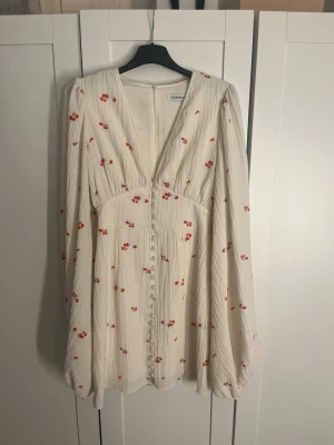 Klänning från Adoore florence dress i storlek 32/xxs/xs - Supersöt vit kortklänning från Adoore med små röda blommor, v-ringning och knappar framtill. Klänningen har långärmade puffärmar och klänningen är i mycket bra skick och knappast använd. Det är färgen white rose. Pris ej hugget i sten och bara att skriva och fråga ifall det finns nån fundering.💕