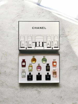 Chanel parfymset - Exklusivt parfymset från Chanel med tolv miniflaskor i olika färger och former. Setet innehåller klassiker som N°5, Coco Noir, Bleu de Chanel och flera varianter av Chance. Flaskorna är i glas och kommer i en elegant vit presentask med svart tryck. En flaska läckte tyvärr när jag fick den. Skriv gärna!