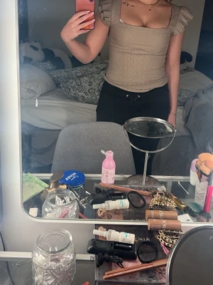 Beige topp med volangärmar från Aim'n - Supersöt beige topp från Aimsu med fyrkantig ringning och volangdetaljer på ärmarna. Toppen är figurnära och har en mjuk, stretchig känsla som passar perfekt till jeans eller kjol. Stilren och enkel att matcha med olika accessoarer.