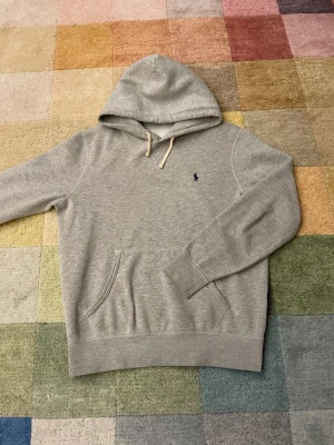 Grå hoodie från Polo Ralph Lauren -  Grå hoodie från Polo Ralph Lauren i storlek M och i bra skick. Skriv vid funderingar.